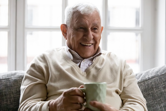 Happy man with coffee sitting down
