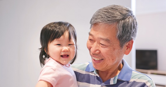 Grandpa holds smiling grandchild