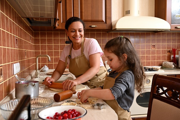 Woman helping her daughter prepare food to cook