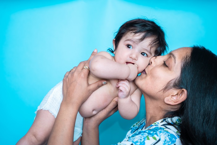 Woman kissing her newborn baby