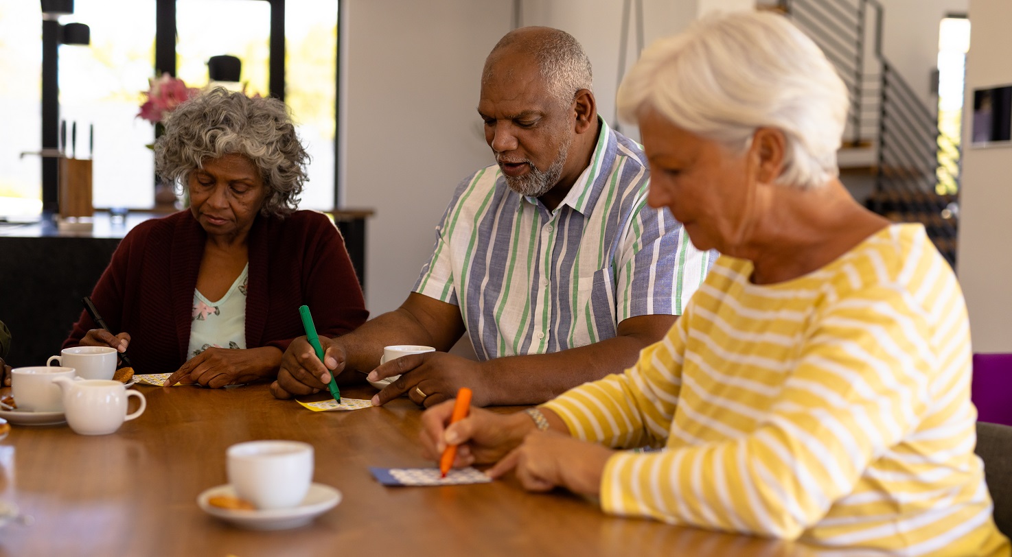 Woman centered in the middle of a group talking and holding her coffee mug